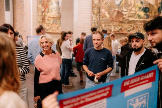 Studenten presenteren hun plannen voor verbetering van hun leefomgeving aan de wethouder van onderwijs van de gemeente Nijmegen